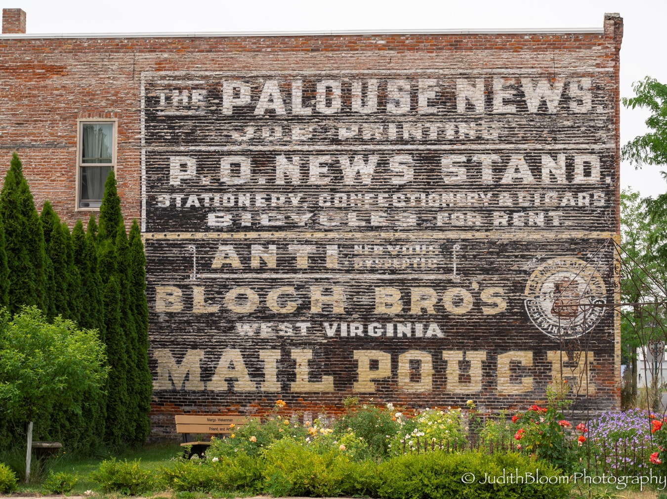 Faded ghost sign on a Palouse brick wall advertising The Palouse News, P.O. News Stand, and Mail Pouch tobacco